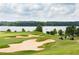 Scenic golf course with lush green fairways, sand traps, and a view of a lake in the background at 6801 Louis Dr, Locust Grove, GA 30248