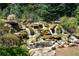 Picturesque waterfall cascading over rocks, surrounded by lush vegetation and creating a tranquil setting at 6801 Louis Dr, Locust Grove, GA 30248