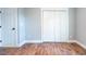 Bedroom with hardwood floors, white trim, and a spacious closet with bifold doors at 1919 Pair Sw Rd, Marietta, GA 30008