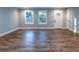Bright living room with hardwood floors, three windows, and a white front door at 1919 Pair Sw Rd, Marietta, GA 30008