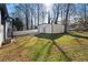 Grassy backyard featuring a detached garage, a white fence, and lush greenery at 441 Windsor Dr, Forest Park, GA 30297
