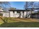 Backyard view of home with a white brick exterior, upper-level deck, and stair access at 441 Windsor Dr, Forest Park, GA 30297