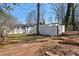 Backyard featuring a detached garage or shed, mature trees, and ample green space at 441 Windsor Dr, Forest Park, GA 30297