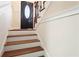 Charming staircase with hardwood steps and white risers leading to a front door with oval glass window at 441 Windsor Dr, Forest Park, GA 30297