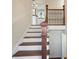 Staircase featuring hardwood steps and wrought iron railing, leading to a modern kitchen at 441 Windsor Dr, Forest Park, GA 30297