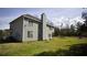 Large grassy backyard featuring the home's rear elevation, chimney, and trampoline for outdoor fun at 70 Woodcliff Way, Covington, GA 30014