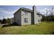 Spacious backyard showcasing the home's gray siding, multiple windows, and chimney, creating a cozy atmosphere at 70 Woodcliff Way, Covington, GA 30014