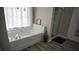Modern bathroom featuring a sleek bathtub with stylish fixtures, alongside a glass-enclosed shower and contemporary design at 70 Woodcliff Way, Covington, GA 30014