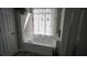 Bright bathroom featuring a tub with window, offering a serene and spa-like atmosphere at 70 Woodcliff Way, Covington, GA 30014