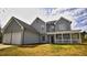 Two-story home featuring a covered porch, attached two car garage, and well-maintained lawn at 70 Woodcliff Way, Covington, GA 30014