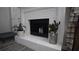 Cozy white brick fireplace with decorative accents and painted mantel, perfect for a warm and inviting living space at 70 Woodcliff Way, Covington, GA 30014