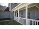 Charming home's front porch features white railings and pillars, plus freshly painted gray brick facade at 70 Woodcliff Way, Covington, GA 30014