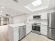 Open-concept kitchen with stainless steel appliances, quartz countertops, and durable floors leading to the living room at 803 New Horizon St, Powder Springs, GA 30127