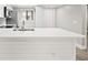 Bright kitchen island with a double sink, white cabinets and light wood laminate flooring at 803 New Horizon St, Powder Springs, GA 30127