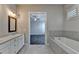Luxurious bathroom with double vanities and a soaking tub that leads to the main bedroom at 1043 Harvest Park Ln, Suwanee, GA 30024