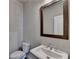 Modern bathroom with a large framed mirror, pedestal sink, and a sleek white toilet at 1043 Harvest Park Ln, Suwanee, GA 30024
