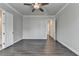 Spacious bedroom with a ceiling fan and hardwood floors that leads to another bedroom at 1043 Harvest Park Ln, Suwanee, GA 30024