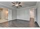Spacious bedroom with a ceiling fan and hardwood floors that leads to the main bathroom at 1043 Harvest Park Ln, Suwanee, GA 30024