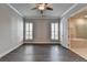 Spacious bedroom with a ceiling fan and hardwood floors that leads to the main bathroom at 1043 Harvest Park Ln, Suwanee, GA 30024