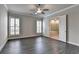 Spacious bedroom with a ceiling fan and hardwood floors that leads to the main bathroom at 1043 Harvest Park Ln, Suwanee, GA 30024