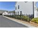 Side view of a white home with black fence and landscaping at 1043 Harvest Park Ln, Suwanee, GA 30024