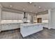 Spacious kitchen with white cabinets, quartz countertops, stainless steel appliances, and large island at 1043 Harvest Park Ln, Suwanee, GA 30024