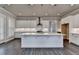 Bright kitchen with white cabinets, large island with sink, and stainless steel appliances at 1043 Harvest Park Ln, Suwanee, GA 30024