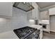 Close-up of a gourmet kitchen featuring white cabinets, subway tile backsplash, and a stainless steel range hood at 1043 Harvest Park Ln, Suwanee, GA 30024