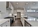 Modern kitchen featuring a large island with sink, stainless steel appliances, and white cabinetry at 1043 Harvest Park Ln, Suwanee, GA 30024