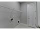 Laundry room with wire shelving, white door and light gray tile flooring at 1043 Harvest Park Ln, Suwanee, GA 30024