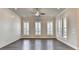 Bright and airy living room with hardwood floors, ceiling fan, and large shuttered windows at 1043 Harvest Park Ln, Suwanee, GA 30024