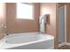 Bright bathroom boasts a new bathtub, shower, and neutral wall paint and flooring at 1152 Werre Way, Locust Grove, GA 30248