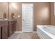 Nice bathroom boasts dark wood cabinets, stone countertops, a bathtub, and decorative hardware at 1152 Werre Way, Locust Grove, GA 30248