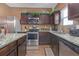 Modern kitchen with granite counters, stainless appliances, and dark cabinetry with under-cabinet lighting at 1152 Werre Way, Locust Grove, GA 30248