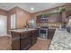 Well-equipped kitchen featuring granite countertops, stainless steel appliances, and dark wood cabinetry at 1152 Werre Way, Locust Grove, GA 30248