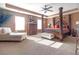 Luxurious main bedroom with decorative tray ceiling, four-poster bed, chaise lounge, and lots of natural light at 1152 Werre Way, Locust Grove, GA 30248
