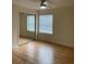 Bright bedroom featuring hardwood floors, a mirrored closet, and natural light from the window at 118 Hawkstone Way, Alpharetta, GA 30022