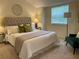 Bright bedroom featuring a tufted headboard, bedside table with lamp, and a window letting in natural light at 118 Hawkstone Way, Alpharetta, GA 30022