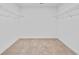 Walk-in closet featuring neutral carpeting and ample space for storage at 1654 Tide Mill Rd, Cumming, GA 30040