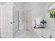 This primary bathroom features a white tile floor, soaking tub, and linen closet at 3595 Evonvale Overlook, Cumming, GA 30041