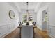 Elegant dining room featuring wainscoting, hardwood floors, and a modern light fixture at 3595 Evonvale Overlook, Cumming, GA 30041