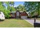 Charming brick home featuring a well-manicured lawn, mature trees, and a two-car garage at 3595 Evonvale Overlook, Cumming, GA 30041