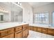 Bright bathroom featuring a soaking tub, white tile floor, and wooden vanity at 100 Hamilton Glen Ct, Fayetteville, GA 30215
