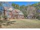 Charming two-story brick home with blue shutters and attached garage and shed in a wooded area at 100 Hamilton Glen Ct, Fayetteville, GA 30215