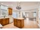 Updated eat-in kitchen with an island, neutral tile floors, and views into the living room and fireplace at 100 Hamilton Glen Ct, Fayetteville, GA 30215