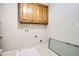 A utilitarian laundry room with plumbing hookups and convenient cabinet storage for added functionality at 100 Hamilton Glen Ct, Fayetteville, GA 30215