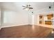 Open living room with hardwood floors, neutral walls, and partial kitchen view at 100 Hamilton Glen Ct, Fayetteville, GA 30215