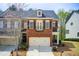 Charming brick townhome featuring a two-car garage and traditional architectural details at 1111 Newpark View Pl, Mableton, GA 30126