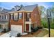 Brick townhome showcasing the side exterior, a well-manicured lawn, and mature trees at 1111 Newpark View Pl, Mableton, GA 30126