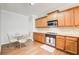 A kitchen with wood cabinets, stainless steel appliances, and a glass table with metal chairs at 1111 Newpark View Pl, Mableton, GA 30126